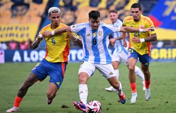 Richard Ríos y Daniel Muñoz en medio del partido contra Argentina en Barranquilla por las Eliminatorias al Mundial 2026, luchando un balón contra Acuña. FOTO: CONMEBOL