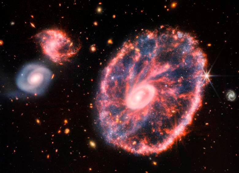 Esta es la galaxia Rueda de Carro ubicada en la constelación de Sculptor, acompañada de otras dos galaxias más pequeñas con un telón de fondo de muchas otras galaxias. Se publicó este 2 de agosto de 2022. Foto: Nasa.