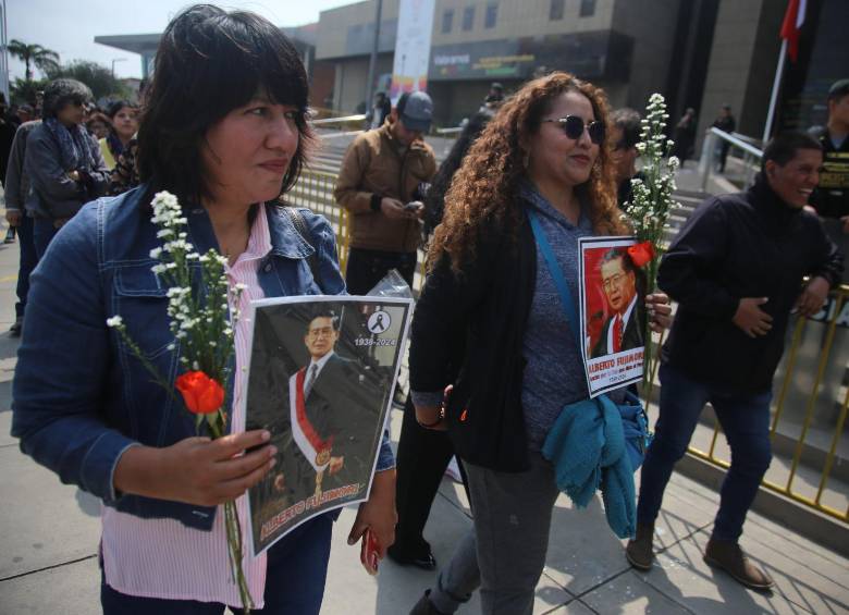 Mujeres despiden a Alberto Fujimori con flores y fotografías en su honor. FOTO: Getty