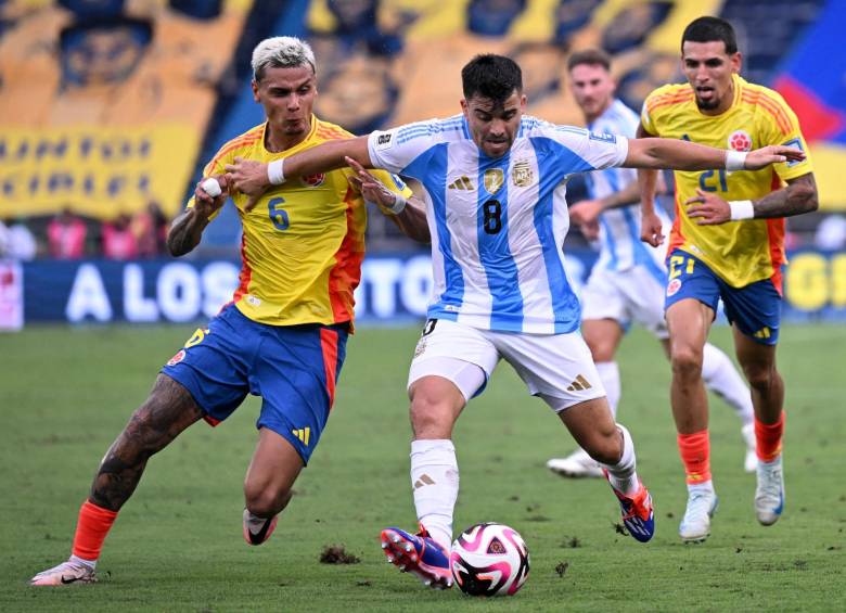 Richard Ríos y Daniel Muñoz en medio del partido contra Argentina en Barranquilla por las Eliminatorias al Mundial 2026, luchando un balón contra Acuña. FOTO: CONMEBOL