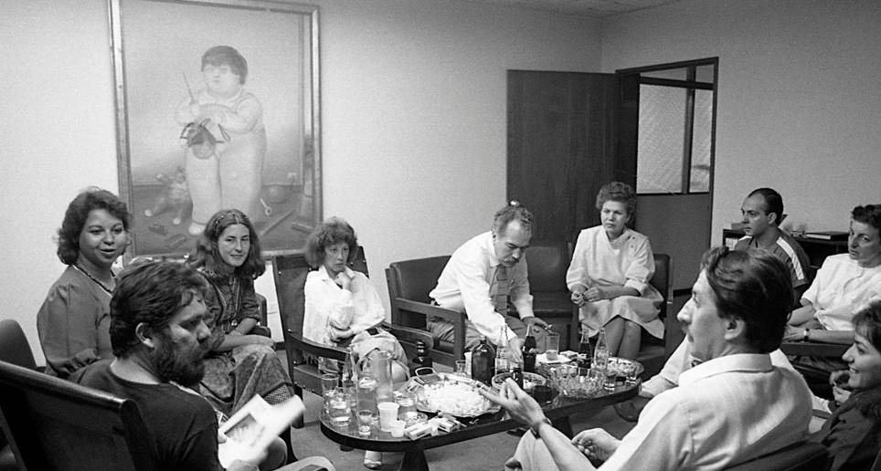 Reunión en la dirección de la Piloto. En los extremos Luis Fernando Peláez y Miguel Escobar. A la izquierda, Gloria Palomino, Tita Maya, Luz Mercedes Cadavid, María José Rodríguez. Manuel, entre todos. Foto Jairo Osorio, del libro iconográfico Manuel revelado.